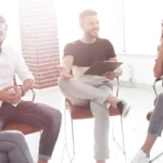Menschen auf Stühlen sitzend im Kreis